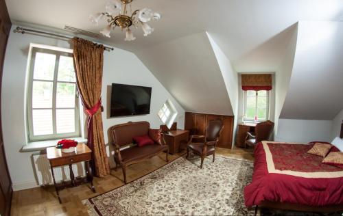 a bedroom with a bed and a desk and a tv at Willa Różana in Nałęczów