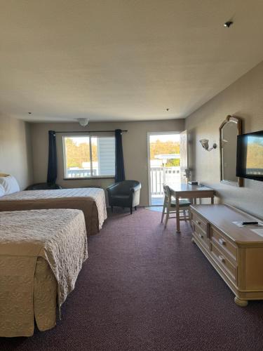 a hotel room with two beds and a desk at Bayview Inn in Crescent City