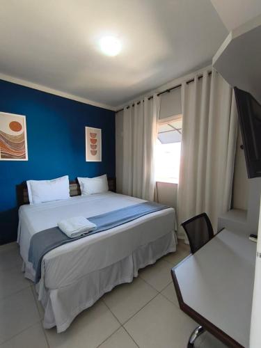 a bedroom with a large bed with a blue wall at Hipolitus Hotel in Lagarto