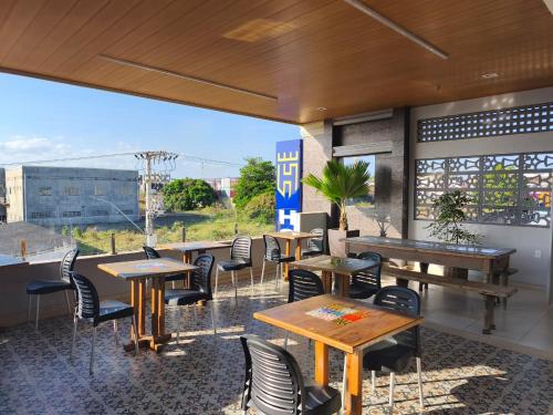 un restaurant avec des tables et des chaises et une grande fenêtre dans l'établissement Hipolitus Hotel, à Lagarto