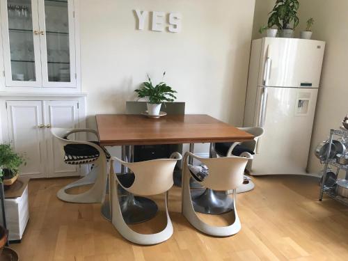a table and chairs in a room with a refrigerator at Luxurious tranquil large bedroom and bathroom suite with rooftop views in interior designed Georgian Townhouse in London
