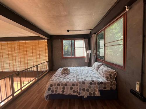 een slaapkamer met een bed in een kamer met ramen bij The Hill Koh Mak 