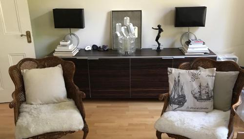 two chairs in front of a desk with two lamps at Luxurious tranquil large bedroom and bathroom suite with rooftop views in interior designed Georgian Townhouse in London