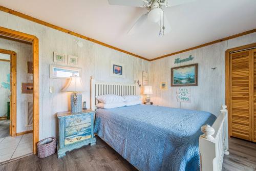 a bedroom with a bed with a blue comforter at This is it - Nags Head MP 16, Ocean View, 75 Yards to Beach, Elevator, Wheelchair Friendly, Flex Stays in Nags Head