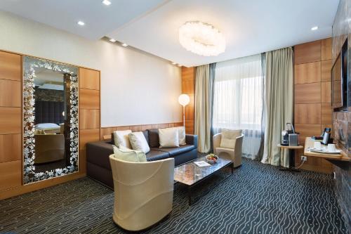 a living room with a couch and a mirror at Hotel St.Gotthard in Zürich