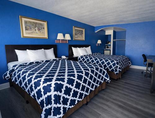 een hotelkamer met 2 bedden en blauwe muren bij Apollo Lodge and RV Park in Fairfield