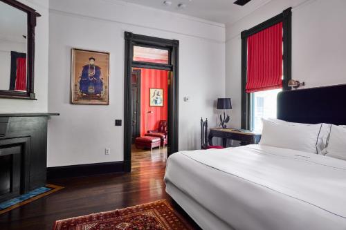 una camera da letto con un letto bianco e un camino di Hotel Saint Cecilia ad Austin