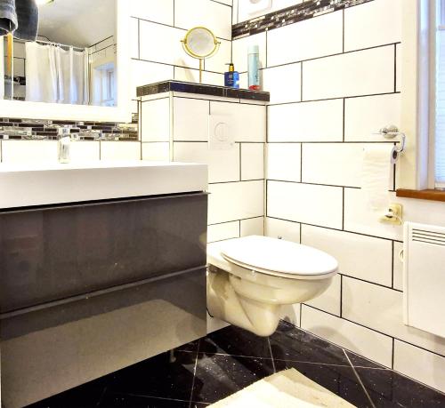 a white bathroom with a toilet and a sink at Unikt sommarboende in Färjestaden