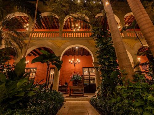 een binnentuin met palmbomen en planten in een gebouw bij Sofitel Legend Santa Clara Cartagena in Cartagena