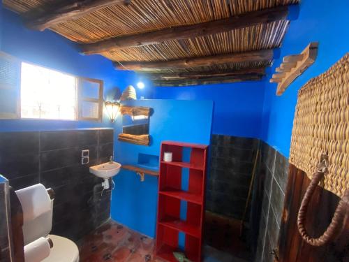 une salle de bain avec des murs bleus et une échelle rouge dans l'établissement Studio Surf House Kaouki, à Sidi Kaouki