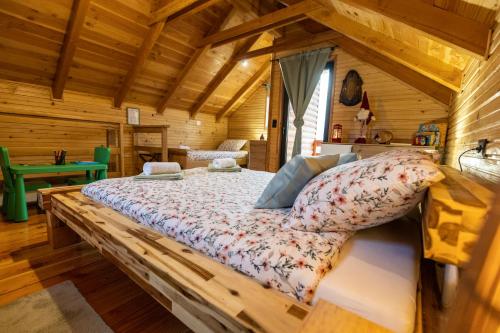 une chambre avec un lit dans une cabane en rondins dans l'établissement Family Oasis, Plaški, à Plaški