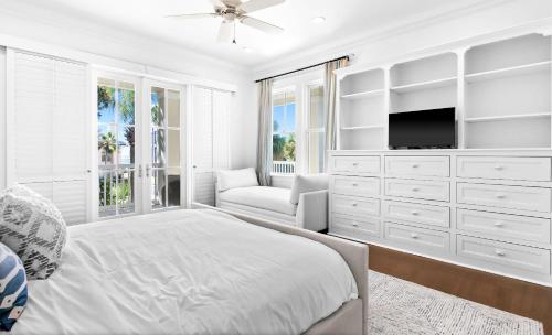 a white bedroom with a bed and a tv at Seagrove Sun in Santa Rosa Beach
