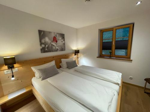 een slaapkamer met een groot wit bed en een raam bij Mountain Lodge in Lenggries