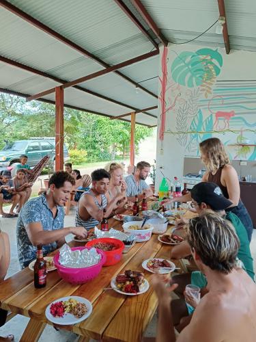 a group of people sitting around a table eating food at Hostal Tortuga Surf in Tonosí