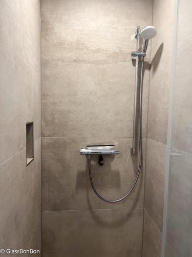 a shower with a hose in a bathroom at Altstadtflair Modernes Studio mit Gartenblick in Neuruppin