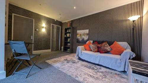 un salon avec un canapé et une chaise dans l'établissement Seaford Snug, à Seaford