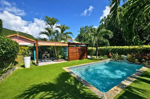 un cortile con piscina e una casa di Mon'Désir Lodge - Bungalows a Case-Pilote