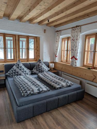 ein großes Sofa in einem Zimmer mit Fenstern in der Unterkunft Sonneckalm in Berchtesgaden in Berchtesgaden