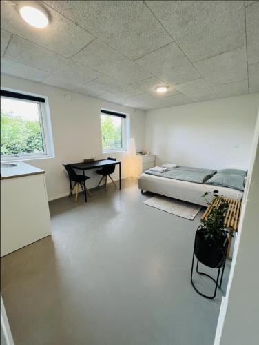 a room with a bed and a table in it at Vejle, Urhoej - Guest Suite in Vejle