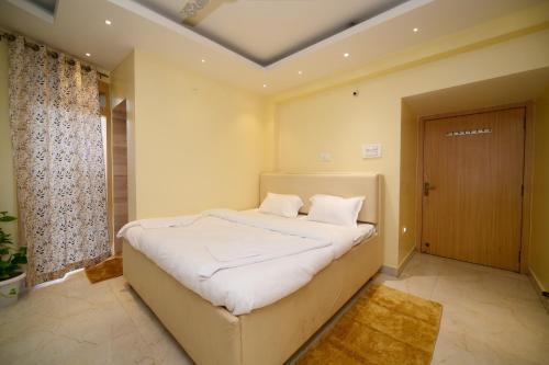 a bedroom with a large bed with white sheets at Airport residency hotel ranchi in Arambol