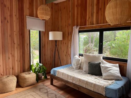 a bedroom with a bed with a large window at Mar de Fondo in La Pedrera