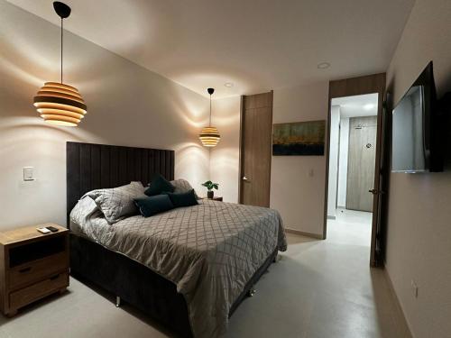 een slaapkamer met een bed en 2 hanglampen bij doca brisa in Santa Marta