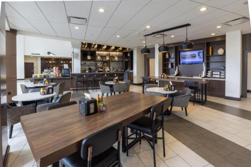 a restaurant with tables and chairs and a bar at Hyatt Place Dallas/The Colony in The Colony
