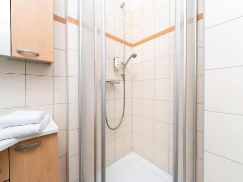 een douche in een badkamer met witte tegels bij elegant eingerichtete Ferienwohnung in Granzow