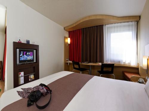una stanza d'albergo con un letto e un tavolo di ibis Hotel Brussels Expo Atomium a Bruxelles
