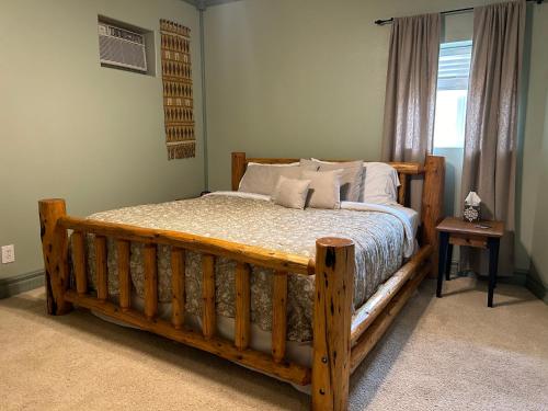 a wooden bed in a bedroom with a window at Devils Tower Lodge Bed & Breakfast in Devils Tower