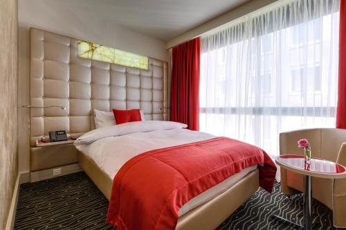 a bedroom with a large bed and a window at Hotel St.Gotthard in Zürich