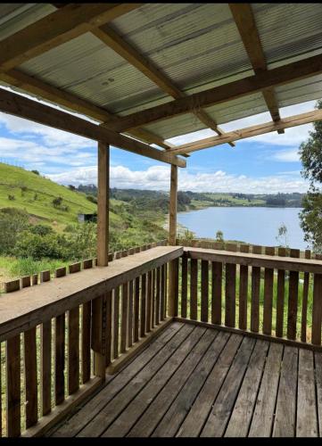 a wooden deck with a view of a lake at Cabaña coñico in Coñico