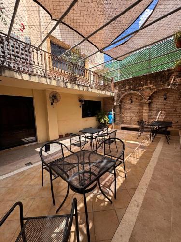 a patio with tables and chairs in a building at HOTEL MATAMOROS frente al consulado in Matamoros