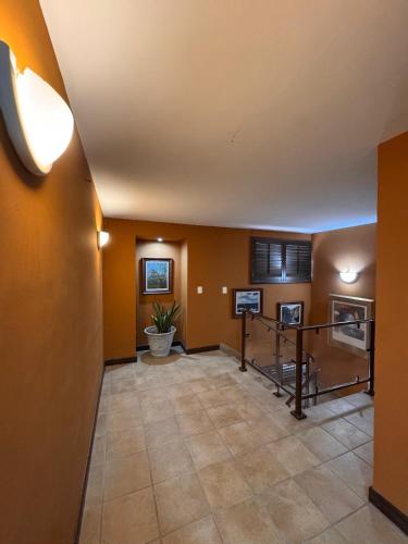 a large hallway with orange walls and a table at HOTEL MATAMOROS frente al consulado in Matamoros