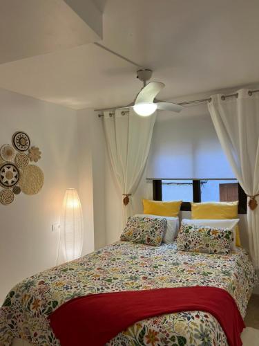 a bedroom with a bed with a red blanket at La Llum de Serra in Serra