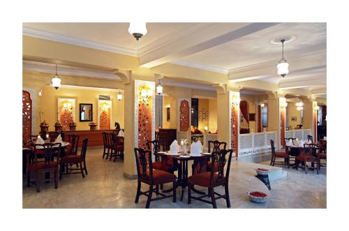 a restaurant with tables and chairs in a room at Ranbanka Palace in Jodhpur