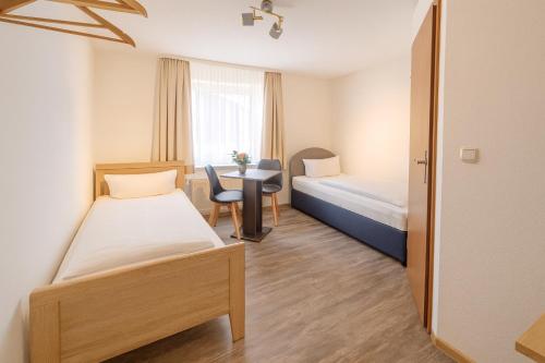 ein Hotelzimmer mit zwei Betten und einem Schreibtisch in der Unterkunft Hotel & Restaurant Hasa in Gernrode - Harz