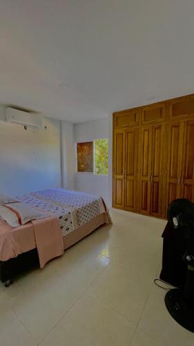 a bedroom with a bed and wooden cabinets at Alojamientos Fredys in Santa Cruz de Mompox