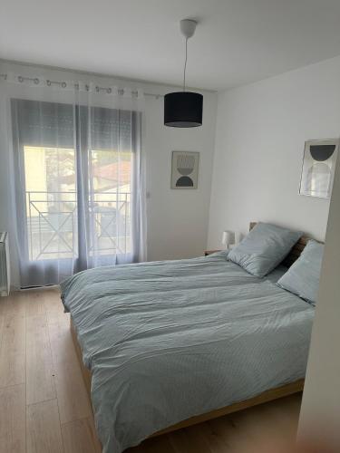 una camera da letto bianca con un letto grande e una finestra di Grand T2 cosy à deux pas de Bordeaux a Cenon