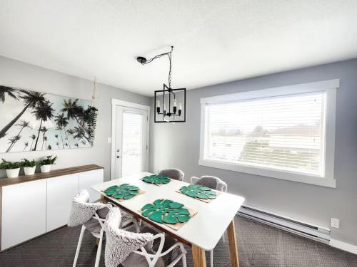 ein Esszimmer mit einem weißen Tisch und Stühlen in der Unterkunft Modern Lake City Getaway in Penticton