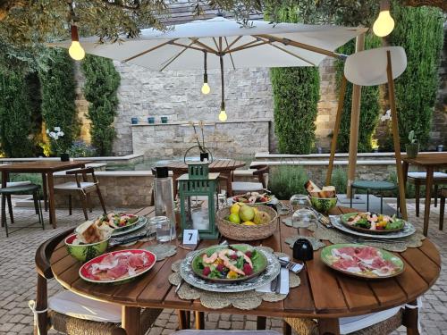 a wooden table with plates of food on it at Eleven, Boutique luxury house & garden in Boliqueime