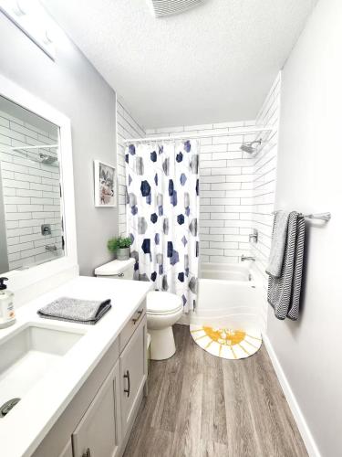 a white bathroom with a toilet and a shower at Modern Lake City Getaway in Penticton