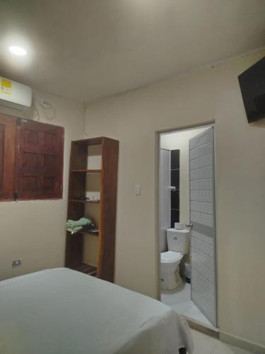 a bedroom with a bed and a bathroom with a toilet at Alojamientos Fredys in Santa Cruz de Mompox