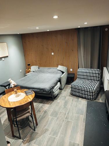 a bedroom with a bed and a table and a chair at Studio cosy in Auby