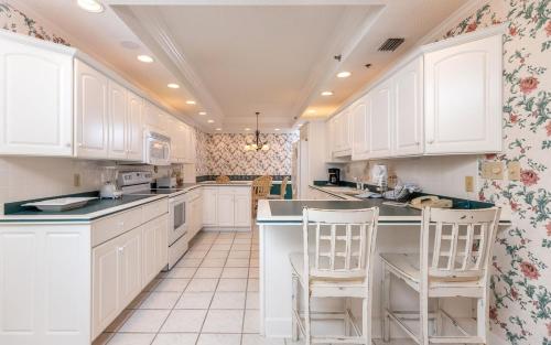 a kitchen with white cabinets and white appliances at Phoenix East 1401 in Orange Beach