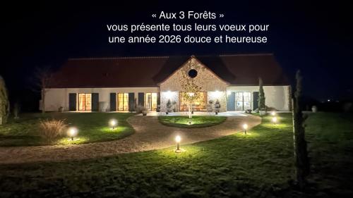 een huis met lichten in de tuin 's nachts bij Aux 3 Forêts in Bizeneuille