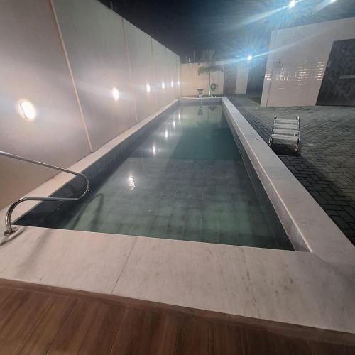 a swimming pool in a building at night at Pedacinho de Lar in João Pessoa