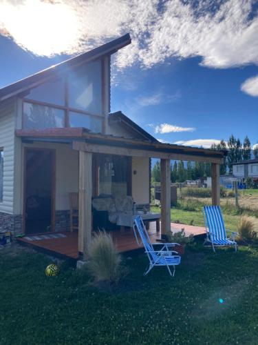 twee blauwe stoelen op de veranda van een huis bij cabaña La Ufu 2 in Las Golondrinas