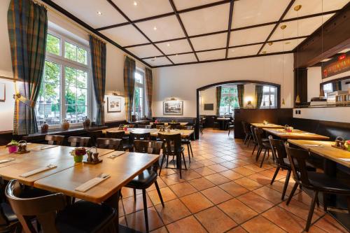 une salle à manger avec des tables et des chaises en bois dans l'établissement Designhotel + CongressCentrum Wienecke XI., à Hanovre