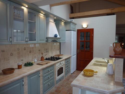 a kitchen with blue cabinets and a stove top oven at Kabóca Vendégház in Vác